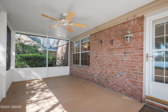 unfurnished sunroom featuring ceiling fan