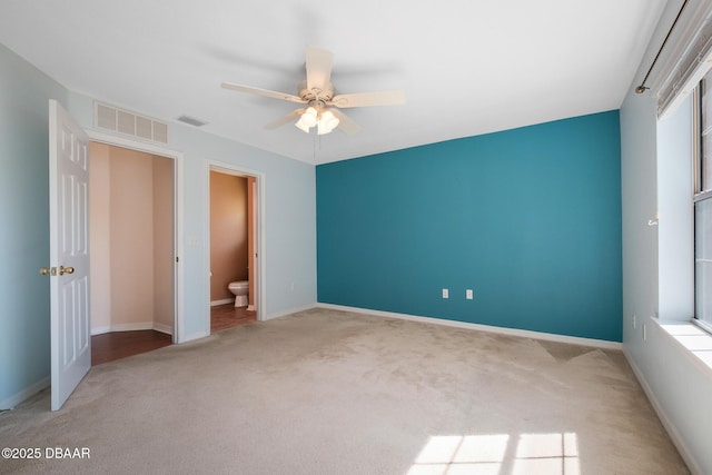 unfurnished bedroom featuring carpet, visible vents, ceiling fan, and baseboards