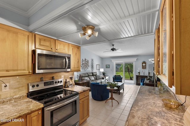 kitchen with ornamental molding, stainless steel appliances, ceiling fan, and light tile patterned floors