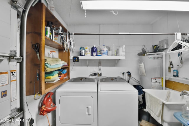 laundry area featuring water heater, sink, and washer and dryer