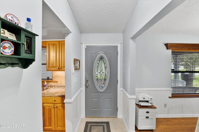 entryway featuring a textured ceiling and light wood-type flooring