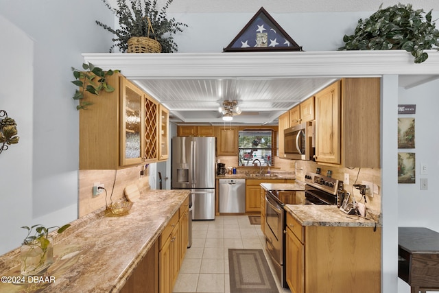 kitchen with stainless steel appliances, light tile patterned flooring, sink, tasteful backsplash, and light stone countertops