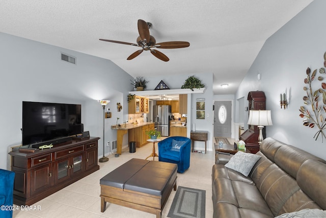 living room featuring ceiling fan, a textured ceiling, light tile patterned floors, and lofted ceiling