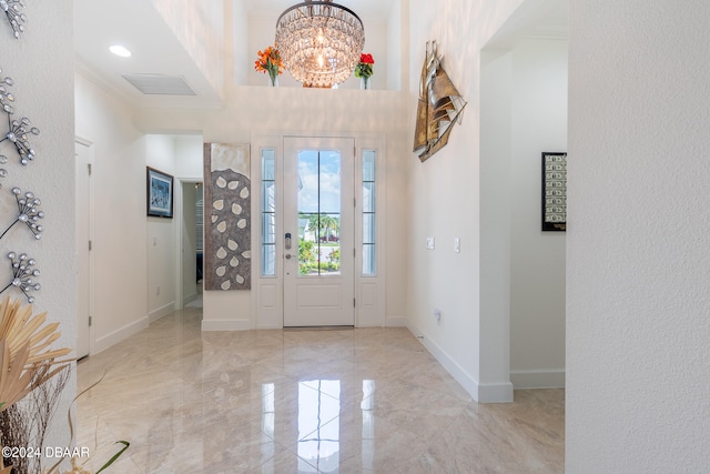 entrance foyer featuring a chandelier and crown molding