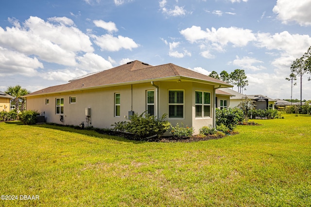 view of property exterior with a lawn and central AC