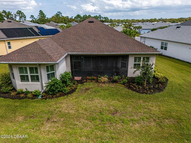 1124 Sea Shell Ct, Daytona Beach, FL 32124 - rear view of house featuring roof with shingles, a sunroom, a yard, and stucco siding