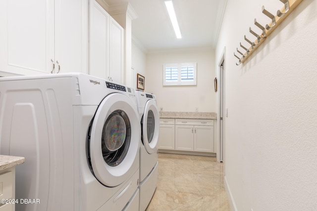 washroom featuring washing machine and dryer, cabinets, and ornamental molding