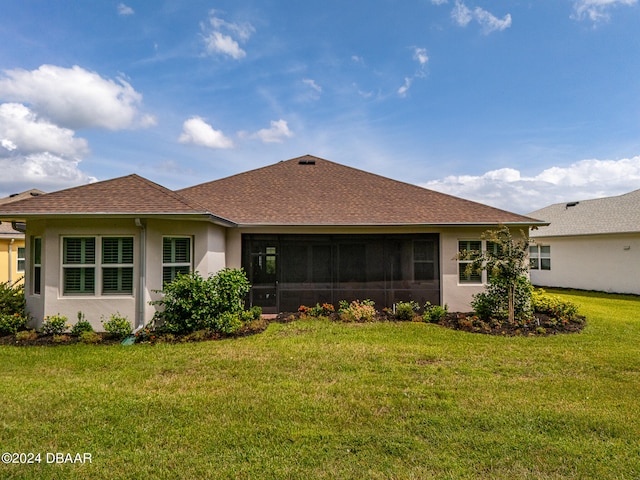 back of property with a lawn and a sunroom