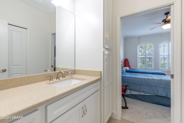 bathroom featuring tile patterned flooring, ornamental molding, ceiling fan, a textured ceiling, and vanity