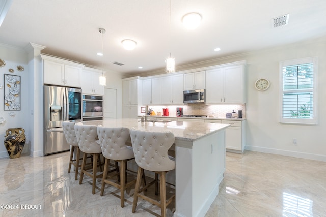 kitchen featuring white cabinetry, a center island with sink, appliances with stainless steel finishes, and crown molding