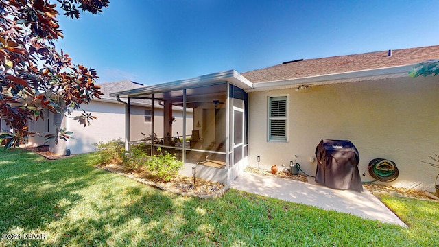 rear view of house featuring a sunroom, a yard, and ceiling fan