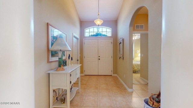 entrance foyer with light tile patterned flooring and vaulted ceiling