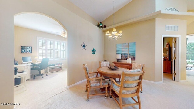 dining room with ceiling fan with notable chandelier, carpet flooring, and high vaulted ceiling