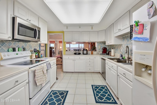 kitchen featuring appliances with stainless steel finishes, sink, light tile patterned floors, and white cabinets