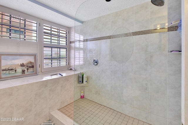 bathroom featuring a textured ceiling and tiled shower