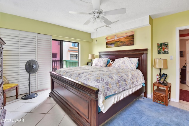 bedroom featuring a textured ceiling, light tile patterned floors, ceiling fan, and access to exterior