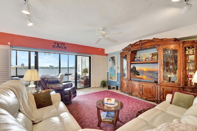 tiled living room featuring plenty of natural light, a textured ceiling, and ceiling fan