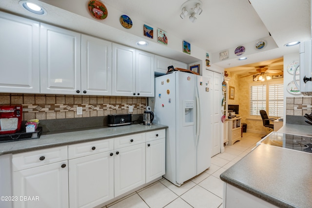 kitchen with white refrigerator with ice dispenser, light tile patterned floors, decorative backsplash, white cabinets, and ceiling fan