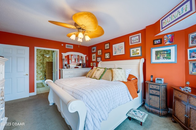 bedroom featuring light carpet, ceiling fan, and connected bathroom