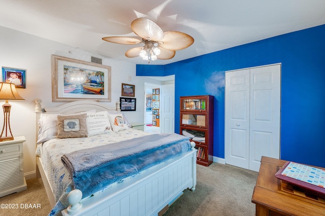 carpeted bedroom featuring ceiling fan and a closet