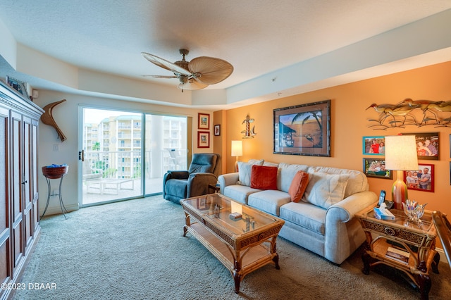 living room featuring a textured ceiling, carpet flooring, and ceiling fan