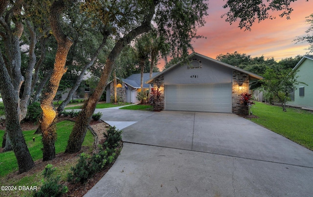 4791 S Peninsula Dr, Ponce Inlet, FL 32127 - view of front of house with a lawn, an attached garage, and concrete driveway