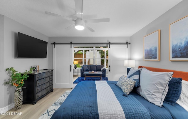 4791 S Peninsula Dr, Ponce Inlet, FL 32127 - bedroom with a ceiling fan, access to exterior, a barn door, and light wood-type flooring