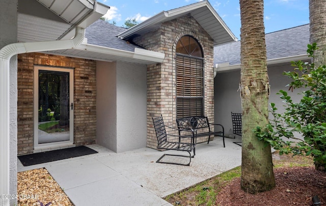 4791 S Peninsula Dr, Ponce Inlet, FL 32127 - entrance to property featuring brick siding, a shingled roof, and stucco siding