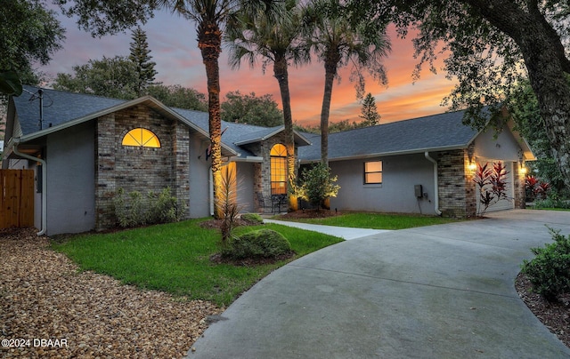 4791 S Peninsula Dr, Ponce Inlet, FL 32127 - view of front of home featuring driveway, roof with shingles, a front yard, stone siding, and stucco siding