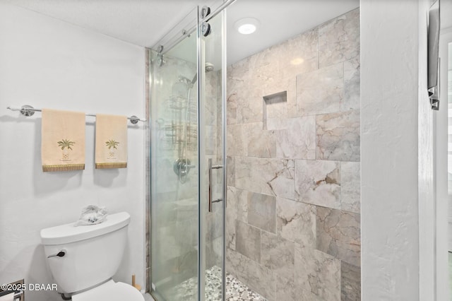 bathroom featuring an enclosed shower and toilet