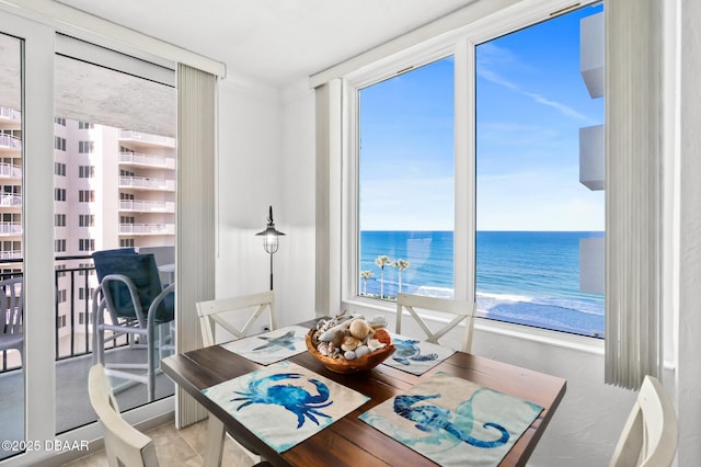 dining room featuring a beach view and a water view