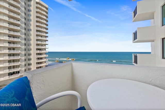 balcony featuring a water view and a beach view