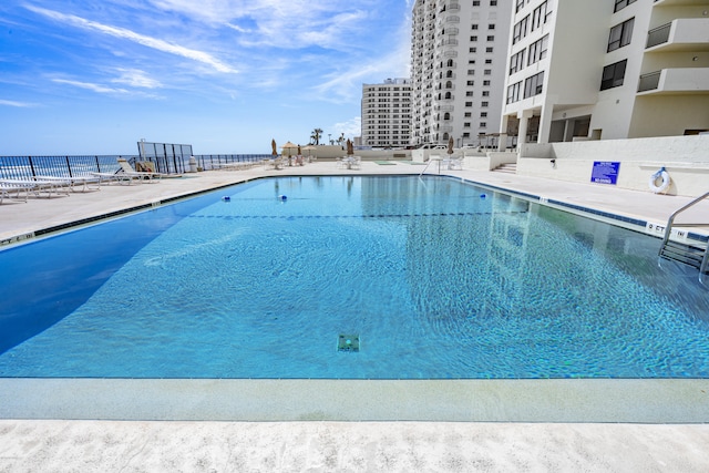 view of pool featuring a patio area and a water view