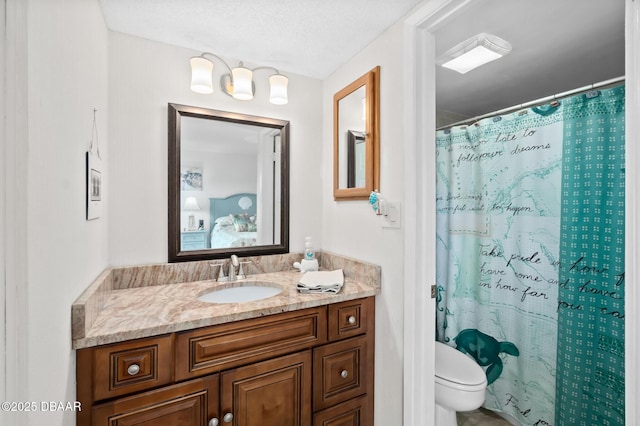 bathroom with vanity, curtained shower, and toilet