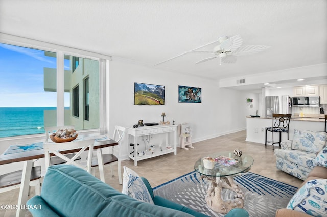 living room with a water view and ceiling fan