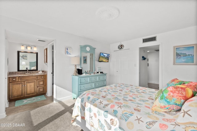 bedroom featuring ensuite bath and a closet