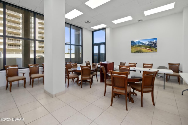 tiled dining space featuring a drop ceiling