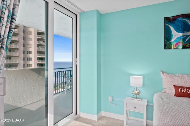 bedroom featuring light carpet and a water view