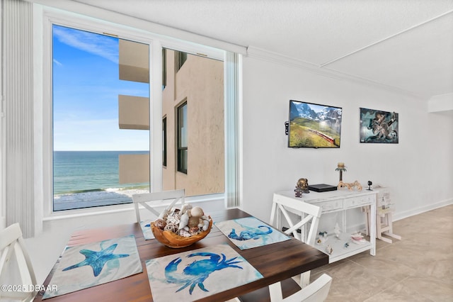 dining space featuring crown molding, a textured ceiling, and a water view