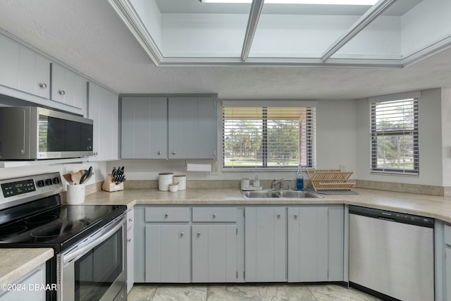 kitchen featuring appliances with stainless steel finishes, a textured ceiling, and sink