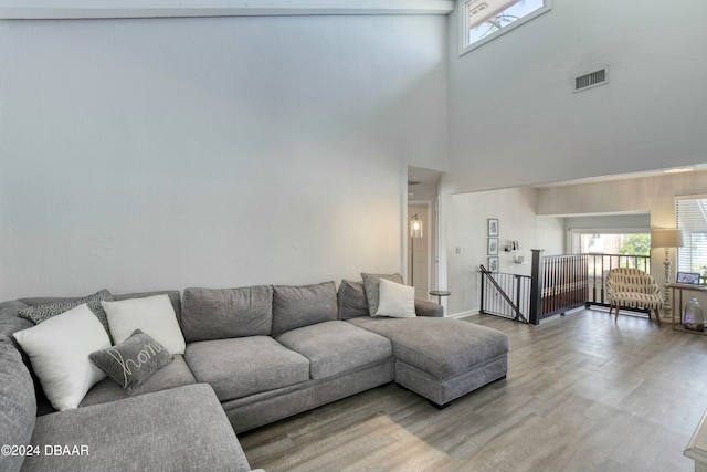 living room featuring wood-type flooring and a high ceiling