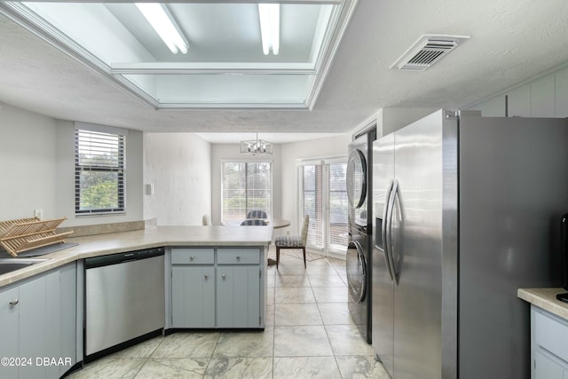 kitchen featuring kitchen peninsula, plenty of natural light, stainless steel appliances, and a textured ceiling