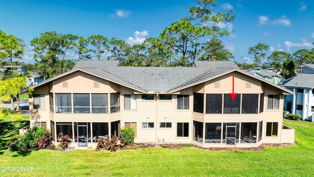 rear view of house featuring a sunroom, a patio area, and a yard