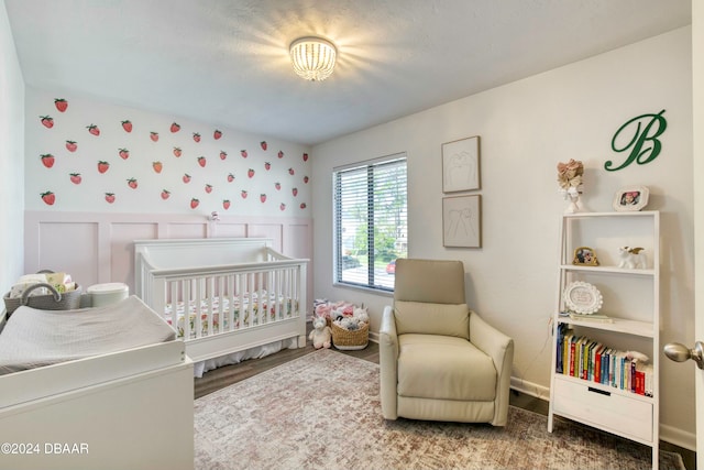 bedroom with hardwood / wood-style floors and a crib