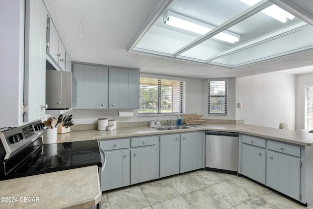 kitchen with a textured ceiling, sink, gray cabinetry, and stainless steel appliances