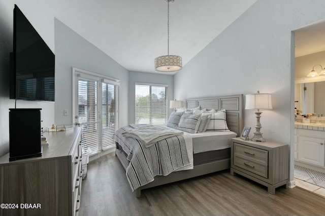 bedroom featuring access to exterior, ensuite bathroom, dark wood-type flooring, and lofted ceiling