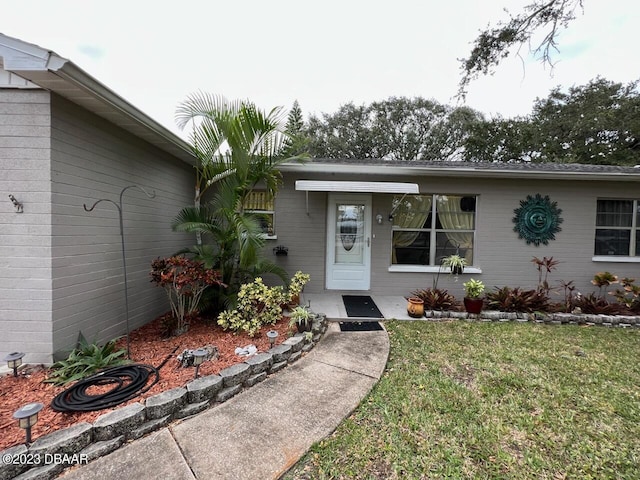 806 E 2nd Ave, New Smyrna Beach, FL 32169 - view of exterior entry featuring a yard