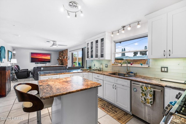 153 University Cir, Ormond Beach, FL 32176 - kitchen with stainless steel dishwasher, a peninsula, open floor plan, light tile patterned floors, and a center island
