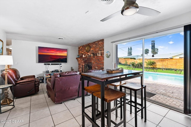 153 University Cir, Ormond Beach, FL 32176 - dining room with a ceiling fan, light tile patterned floors, and a brick fireplace