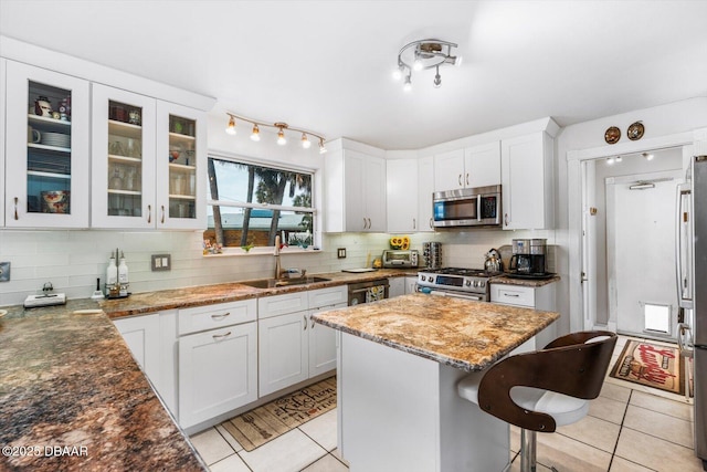 153 University Cir, Ormond Beach, FL 32176 - kitchen featuring stainless steel appliances, light tile patterned flooring, a breakfast bar, and decorative backsplash
